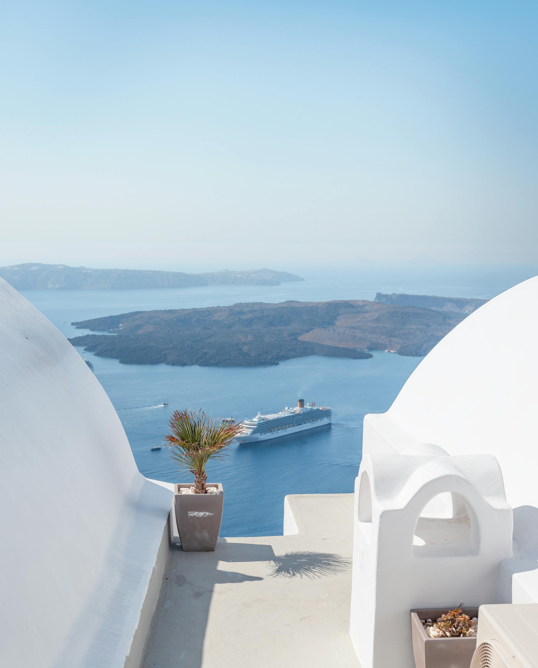 Stunning view of the Aegean Sea with a cruise ship, captured from a rooftop in Fira, Santorini.